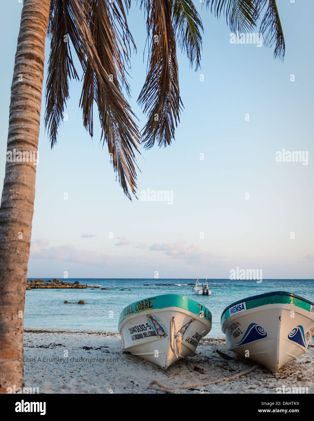 Two boats on a beach at sunset in Cozumel, Mexico Stock Photo