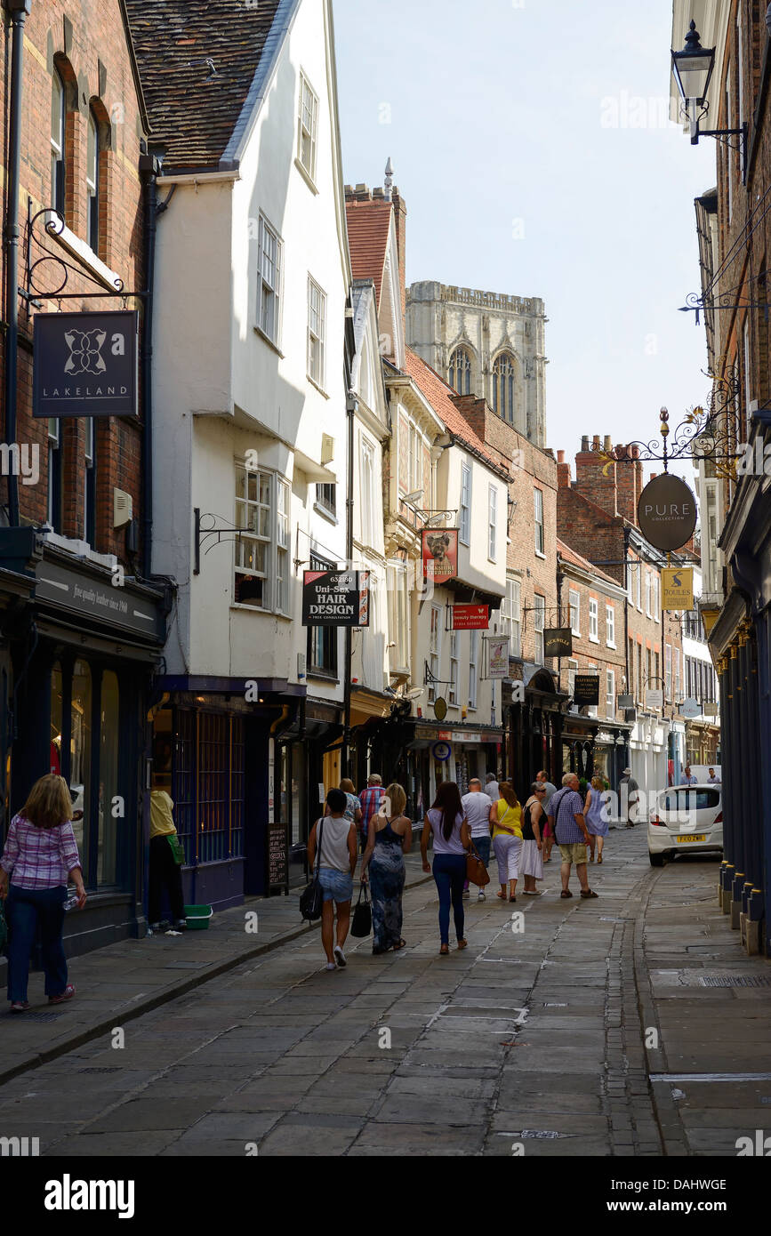 Tourists walking along Stonegate in York city centre towards the Cathedral Stock Photo