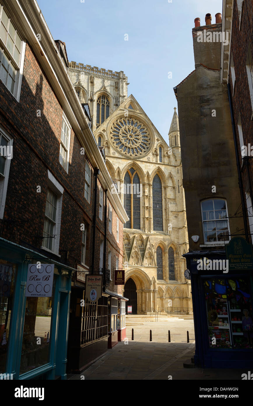 The Cathedral becomes visible through the narrow buildings of Stonegate in the city centre of York UK Stock Photo
