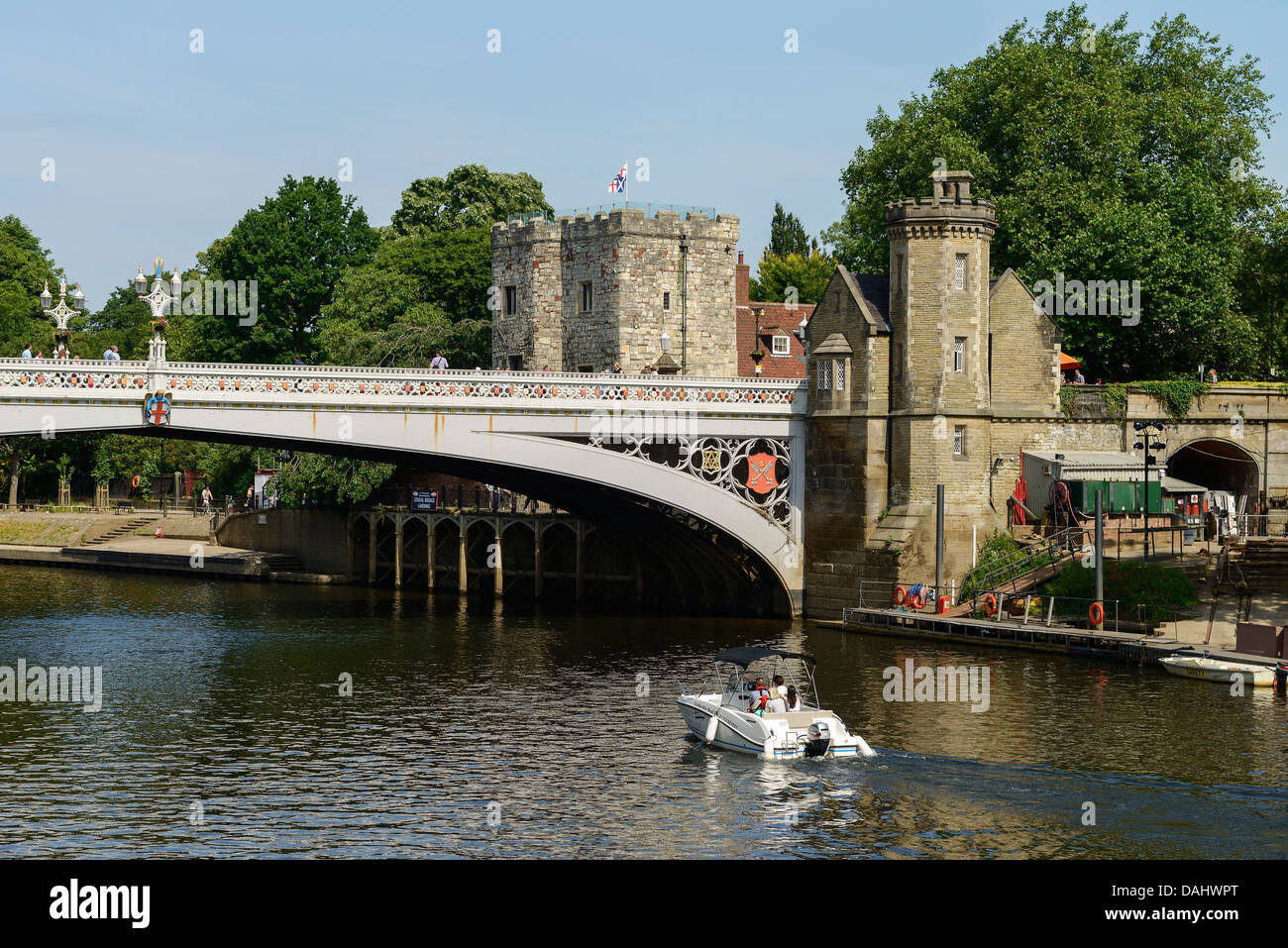 A small pleasure boat on the River Ouse passes under Lendal Bridge in York city centre UK Stock Photo