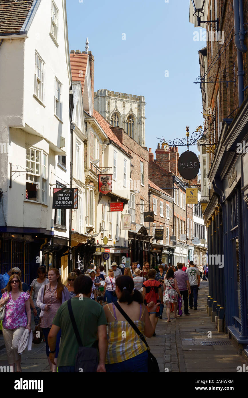 Tourists and shoppers walk along Stonegate near York Cathedral UK Stock Photo