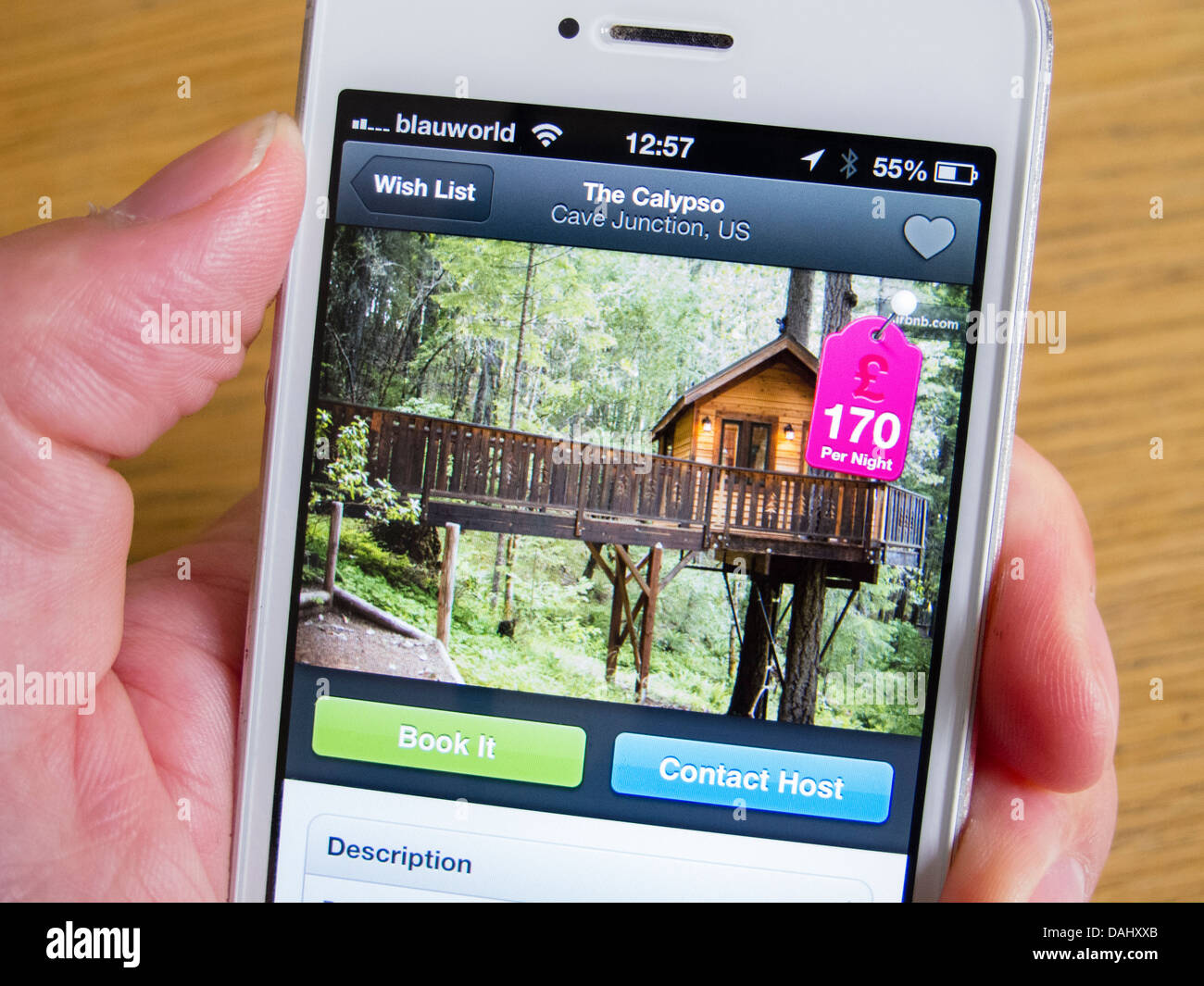 Using Airbnb app to book holiday accommodation in a luxury tree house with an  iPhone 5 smartphone Stock Photo