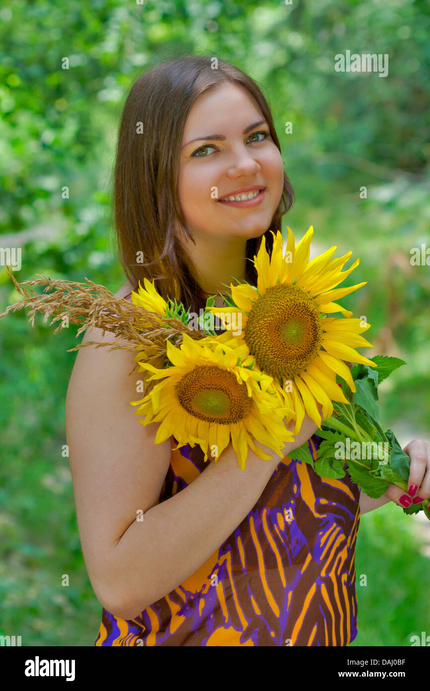 Portrait of young pretty green eyes woman with sunflowers Stock Photo