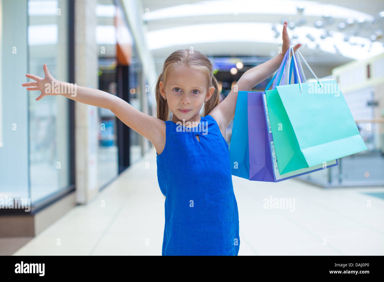 Portrait of little happy girl holding shopping bags at the mall Stock ...