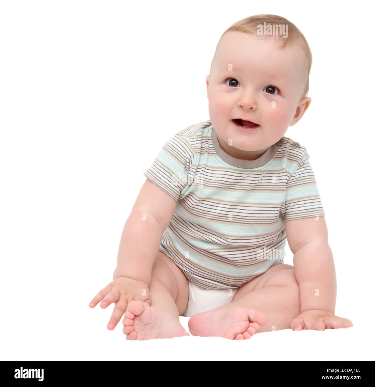 beautiful laughing happy baby boy sitting on white bed Stock Photo