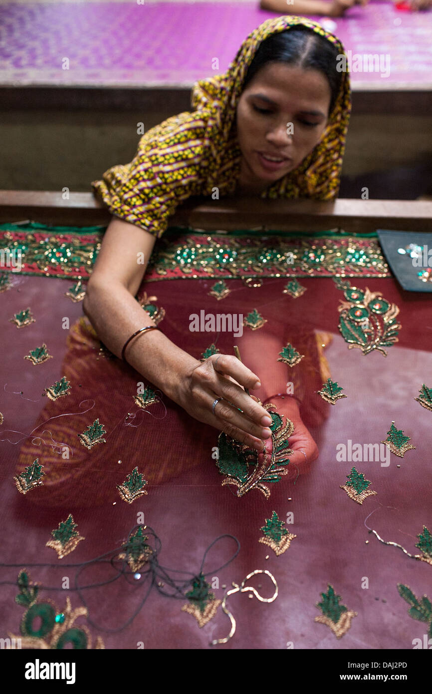 A woman works on details on a traditional Jamdani saree in Mirpur Benarashi Palli, Dhaka, Bangladesh, poor Bengali neighborhood. Stock Photo