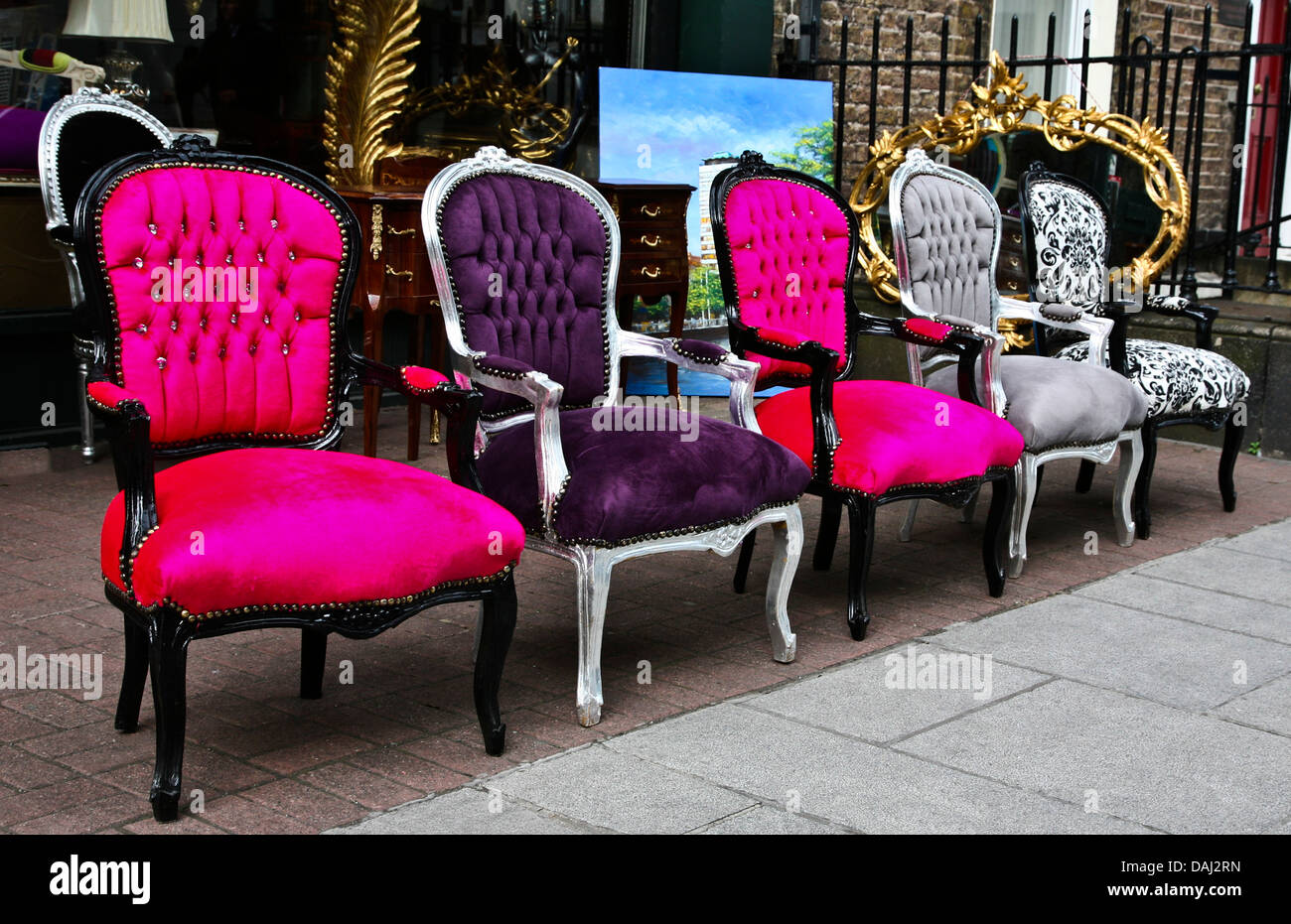 Colorful outdoor close up Victorian antique chairs displayed in a row in front of an antique store in Dublin, Ireland, vintage objects, chair abstract Stock Photo