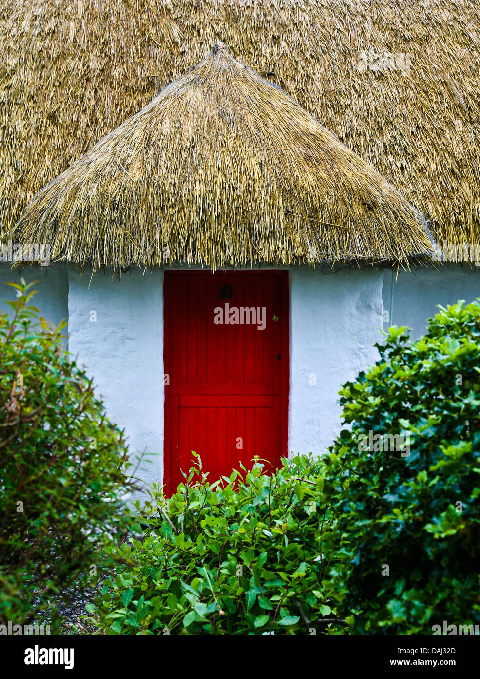 Historic thatched roof Irish cottage with a red colour front door in the Boyne Valley of Ireland, Europe, unusual straw roof cottage enchanted Stock Photo