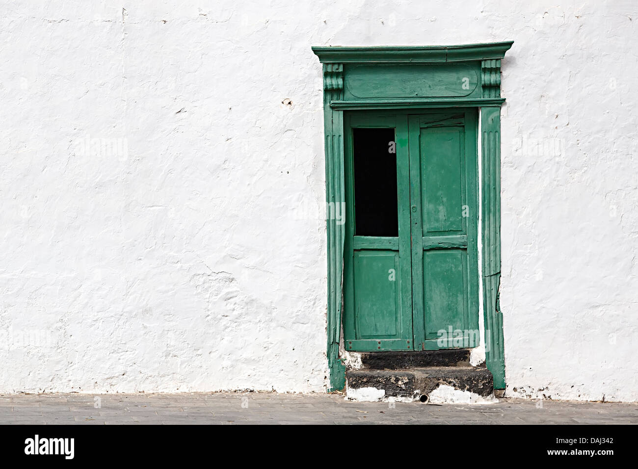 Green painted wooden door in white wall, Teguise, Lanzarote, Canary Islands, Spain Stock Photo