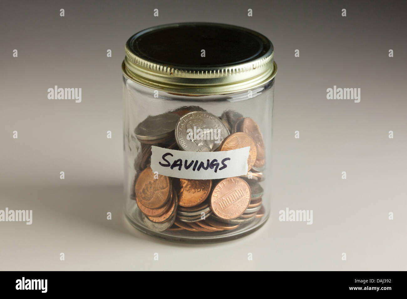 Coins in glass jar for savings Stock Photo