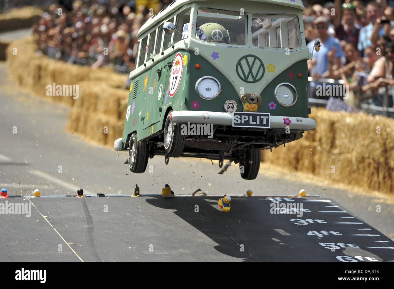 London, UK. 14th July, 2013. The soapbox vehicle for the Hippy Split Camper Van team in mid-air as it jumps over a ramp during the Red Bull Soapbox Race, Alexandra Palace, London, England. At theis stage the vehicle had lost it's front nearside wheel and was about to roll. The Red Bull Soapbox Race returned to London after nine years and encourages competitors to build and race their own homemade soapbox vehicles. Credit:  Michael Preston/Alamy Live News Stock Photo