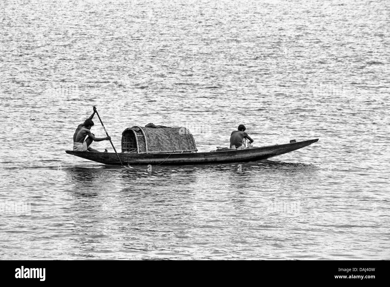 Men rowing a wooden boat along the River Hugli, Kolkata, West Bengal, India Stock Photo