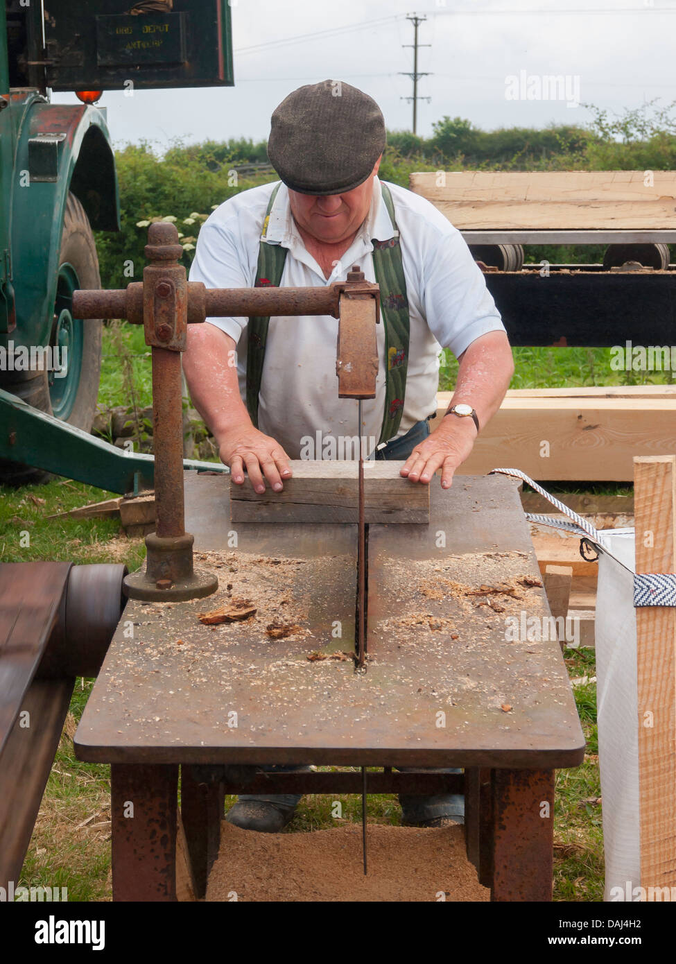 A man demonstrating wood sawing using a circular saw belt driven by a