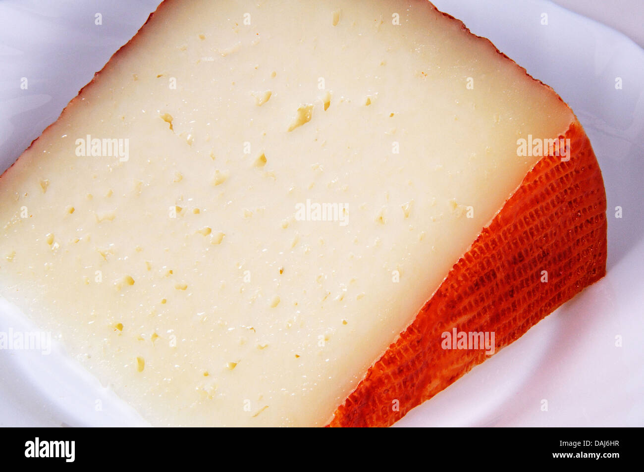 Manchego cheese wedge on a white plate Stock Photo Alamy