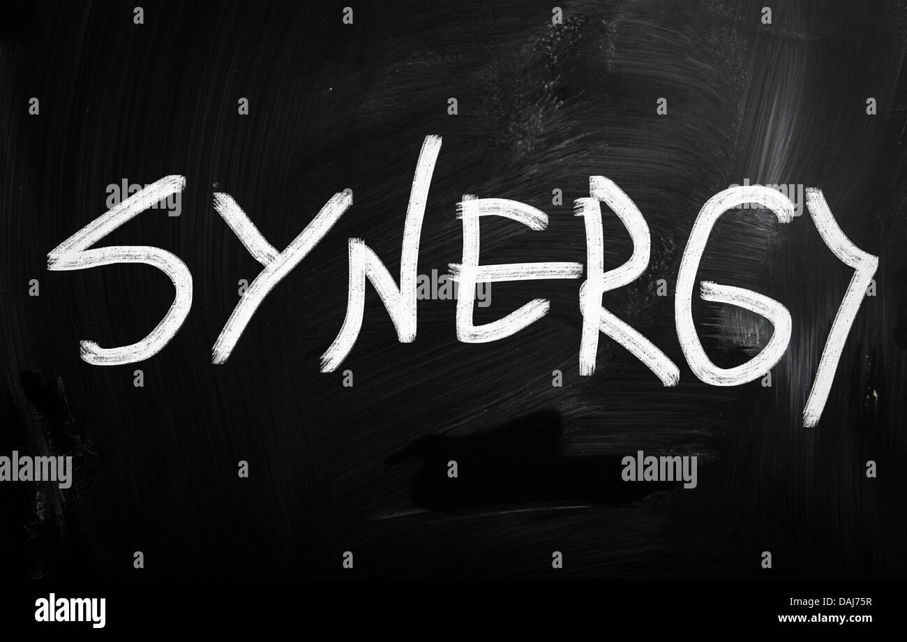 The word 'Synergy' handwritten with white chalk on a blackboard Stock Photo