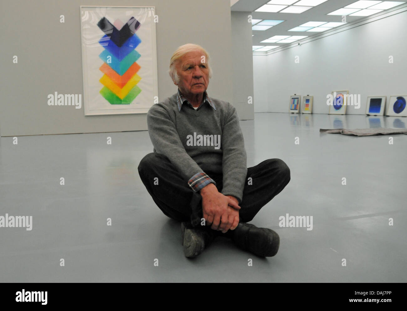 Artist Heinz Mack sits on the floor of his exhibition 'Mack - The Language of his Hand' and in front of his work 'Farbkaskaden 2010' (Colour Cascades 2010) at the Museum Kunstpalast in Duesseldorf, Germany, 21 March 2011. On the occasion of Mack's 80th birhtday, the exhibition presents works of the artist between 26 March and 10 July 2011. Photo: Horst Ossinger Stock Photo