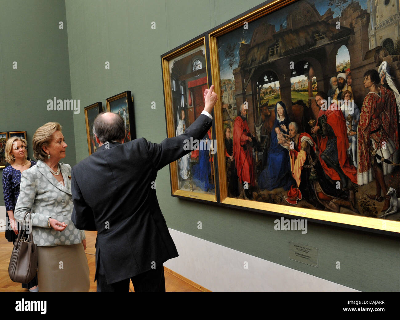 Queen Paola of Belgium (L) looks at the three kings altar by Rogier van der Weyden with the Director of the Bavarian State Collection of Paintings, Martin Schave, in the Alte Pinakothek museum by the curator Miriam Neumeister (R) in Munich, Germany, 30 March 2011. According to statements from German diplomats, the invitation of the Belgian royal couple in meant to show how importan Stock Photo