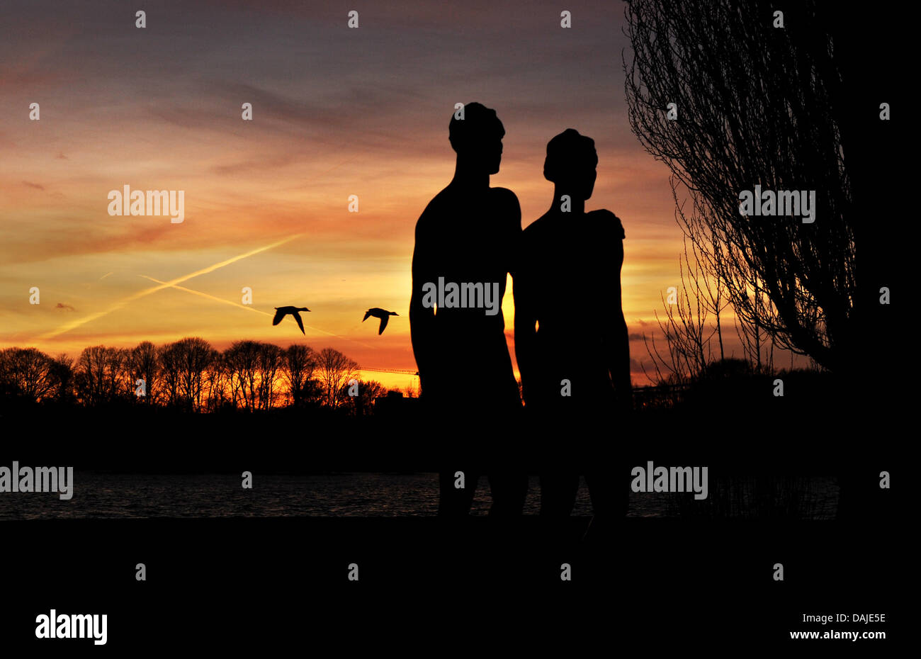 The silhouettes of two ducks and the artwork 'Couple' (1939) by the artist Georg Kolbe are looming at the sunset in Hannover, Germany, 7 April 2011. Meteorologists forecast sunny weather for the weekend. Photo: Julian Stratenschulte Stock Photo