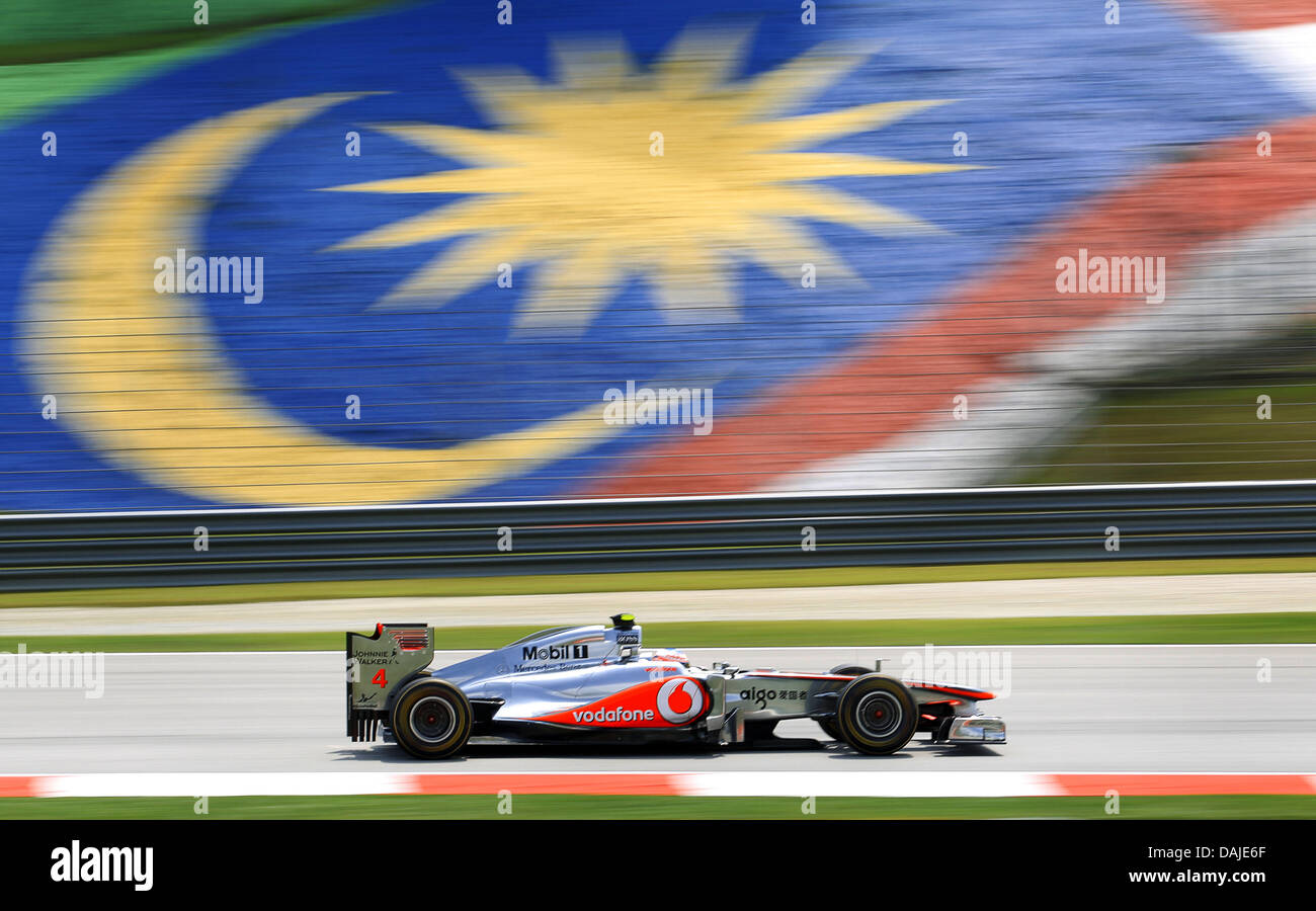 British Formula One driver Jenson Button of McLaren Mercedes steers his car in front of the Malaysian state flag during the second practice session at the Sepang circuit, outside Kuala Lumpur, Malaysia, 08 April 2011. The Formula One Grand Prix of Malaysia will take place on 10 April 2011. Photo: Jens Buettner dpa Stock Photo