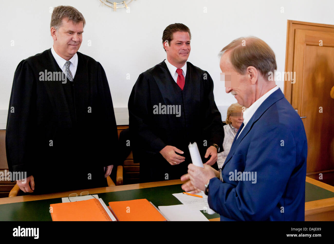 The accused Lothar Anton H. (R) enters together with his wife Rita H. and the lawyers  Horst Kletke (L) and Julian Heiss the court room of the state court in Gießen, German, 8 April 2011. The merchant is accused of having imported and internationally sold drugs between April 2006 and September 2010. In his warehouse customs investigators found illegal drugs with an average value of Stock Photo