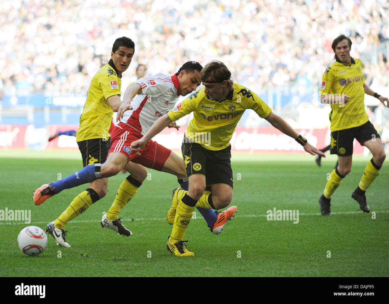 Hamburg's  Aenis Ben-Hatira (C) fights for the ball against Dortmund's Marcel Schmelzer (2nd from R) and Nuri Sahin (L) during the Bundesliga soccer match between Hamburger SV and Borussia Dortmund at the IMtech Arena in Hamburg, Germany, 09 April 2011. Photo: Christian Charisius Stock Photo