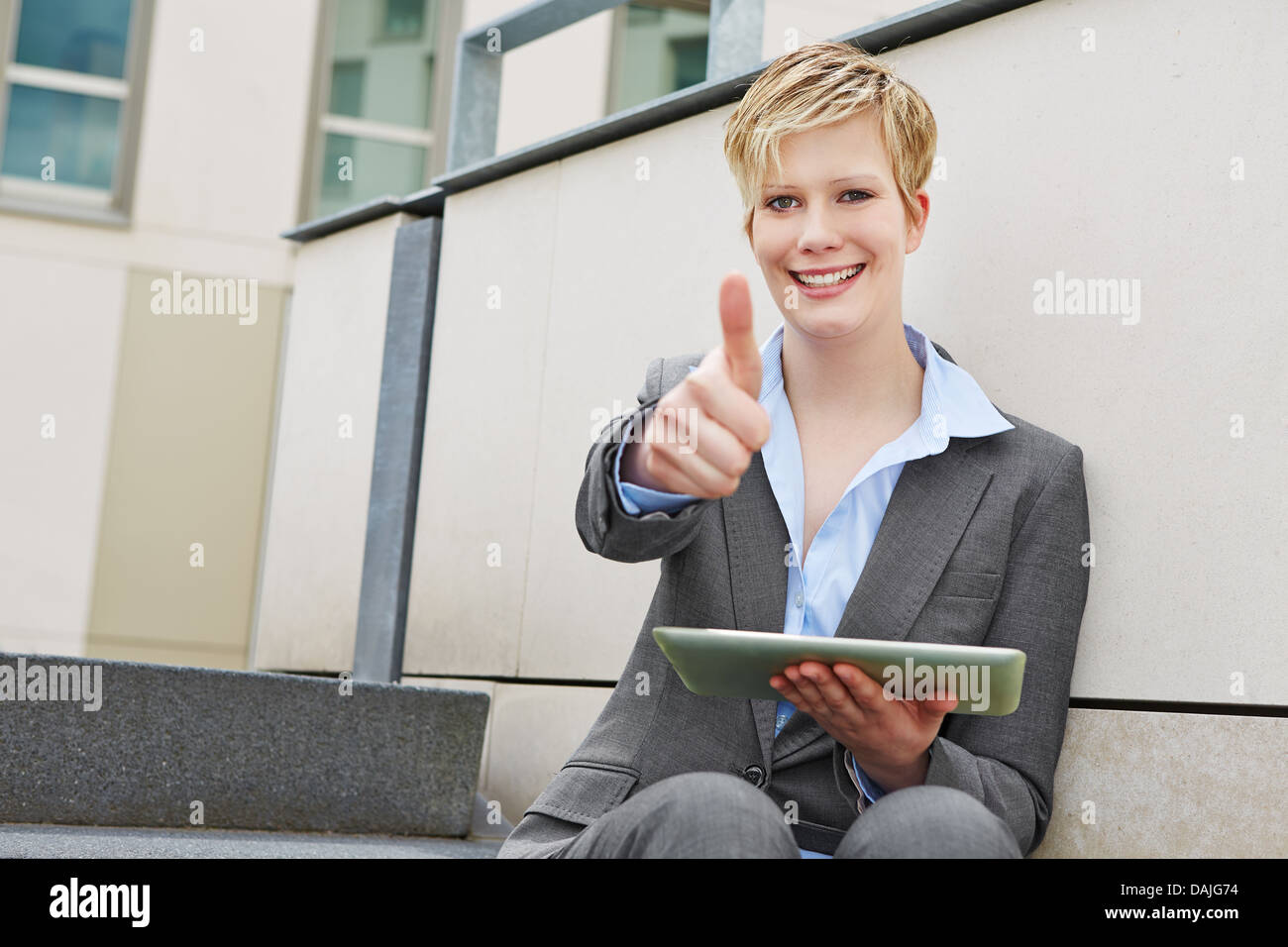 Young happy business woman with tablet computer holding thumbs up Stock ...