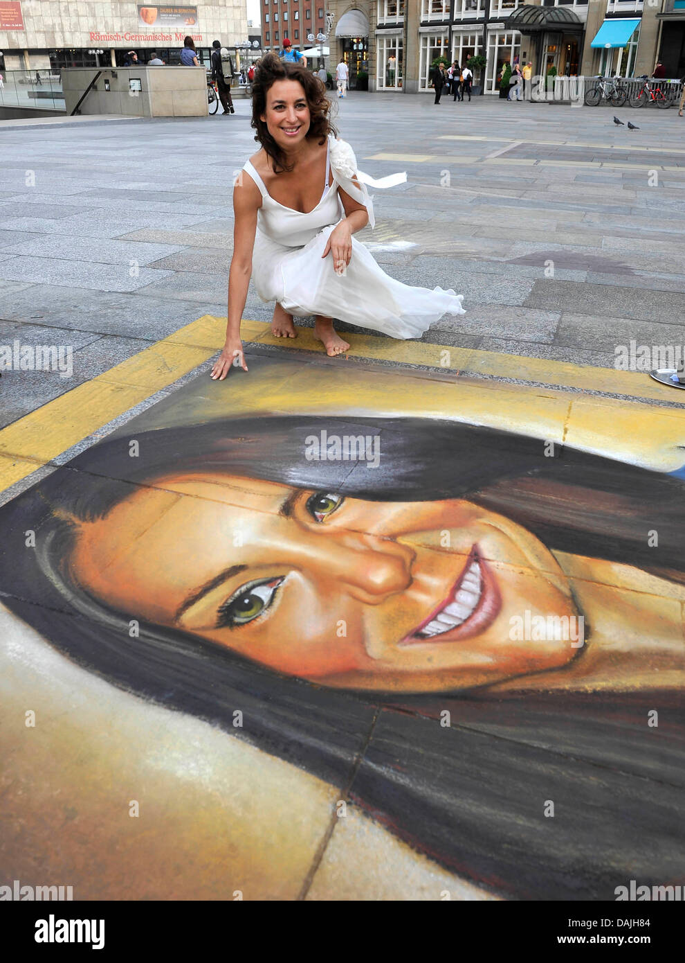 Singer Isabell Varell sits next to a chalk protrait of Kate Middleton, the future wife of Prince William, on the ground in front of the Cathedral during the production of a video in Cologne, Germany, 11 April 2011. Varell is producing a video to her current song 'Es ist nicht leicht Prinzessin zu sein' ('Its not easy to be a princess'). Photo: HENNING KAISER Stock Photo