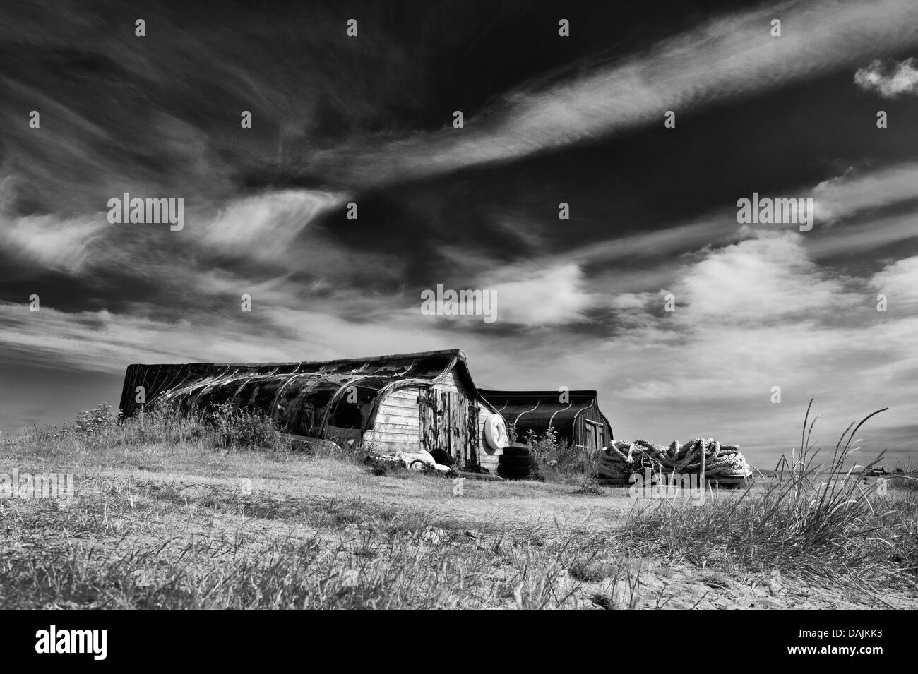 Herring boat sheds in the harbour at Lindisfarne, Northumberland, England. Monochrome Stock Photo