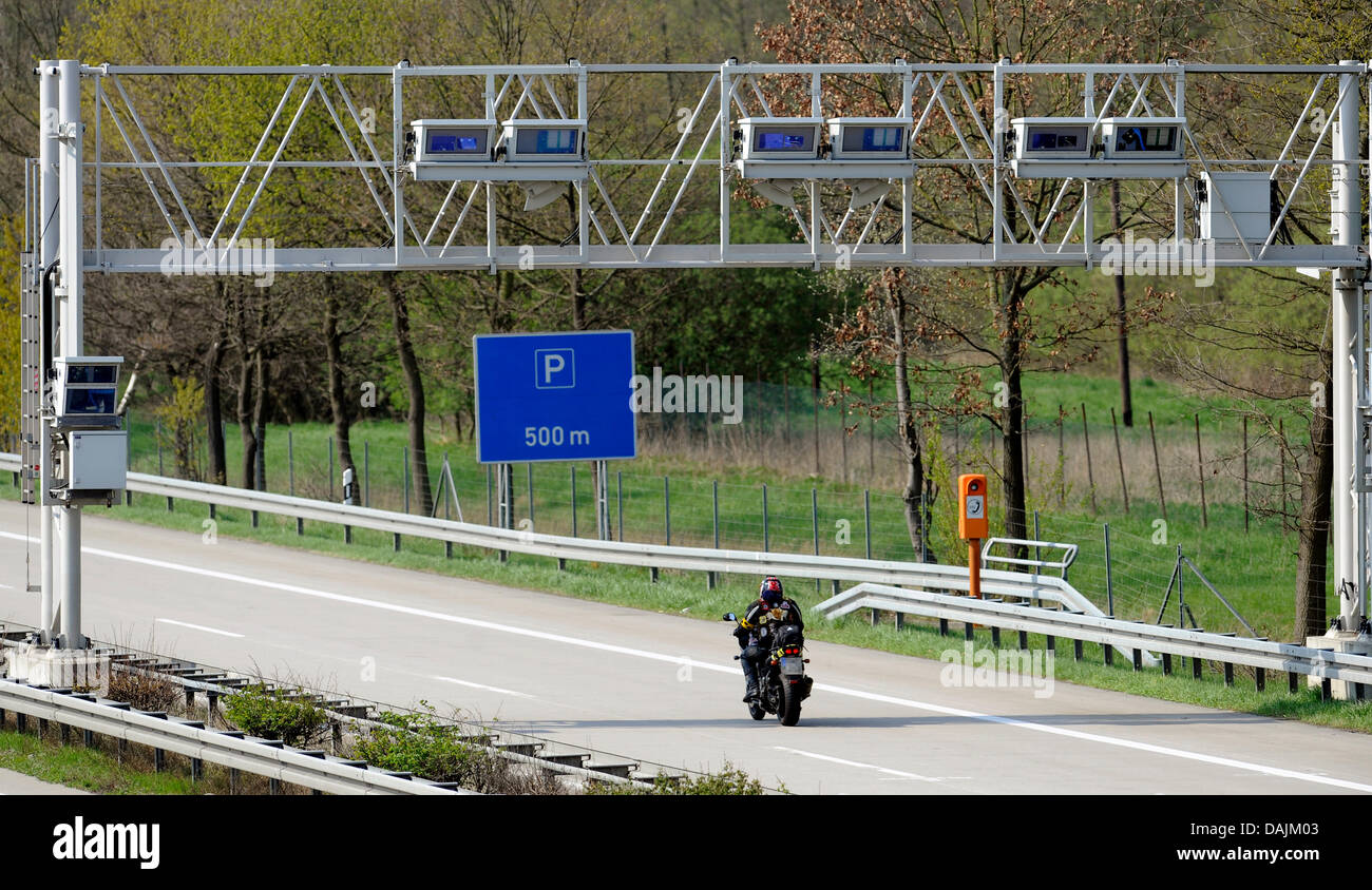 A motorcyclist passes under a road charge bridge on Autobahn A352 north of Hanover, Germany, 18 April 2011. German transport minister Ramsaurer plans, according to tabloid Bild, on an electronic passenger car road tax disc. According to these yet officially unreleased plans, motorcyclists would also have to pay. German Chancellor Merkel has reacted in opposition to the plans. Photo Stock Photo