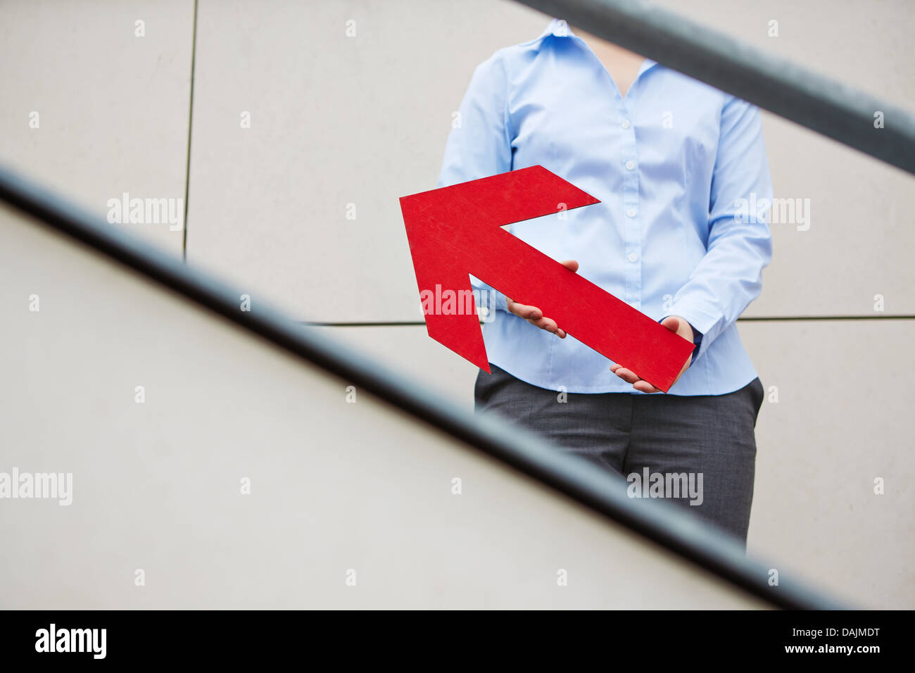 Woman holding red big arrow pointing upwards Stock Photo - Alamy