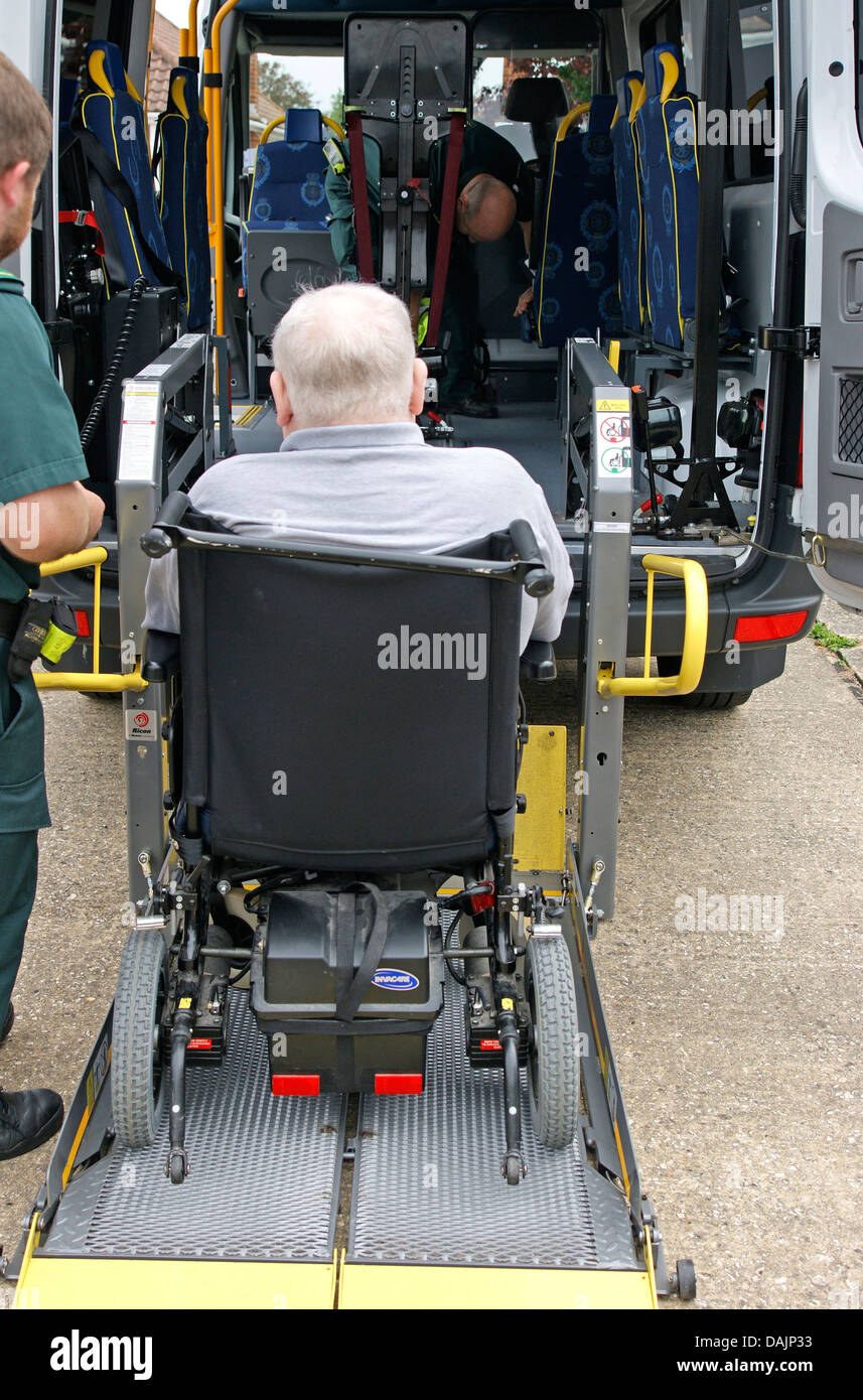 Patient transport West Sussex area ambulance taking a male patient in a wheelchair to hospital Stock Photo