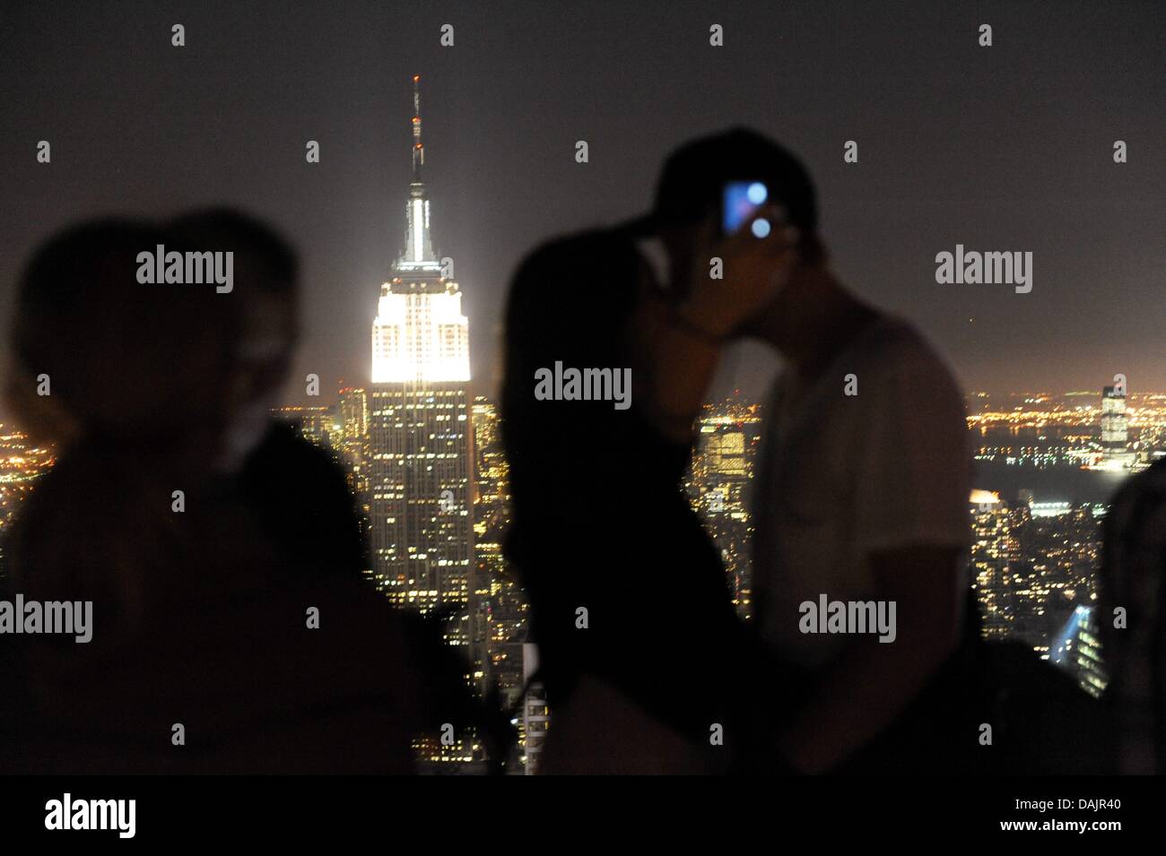 Ein Päärchen küsst sich am  Montag (26.04.2011) auf der Aussichtsplattform des Rockefeller Center vor dem hell erleutchteten Empire State Building in  New York. Foto: Maurizio Gambarini dpa Stock Photo