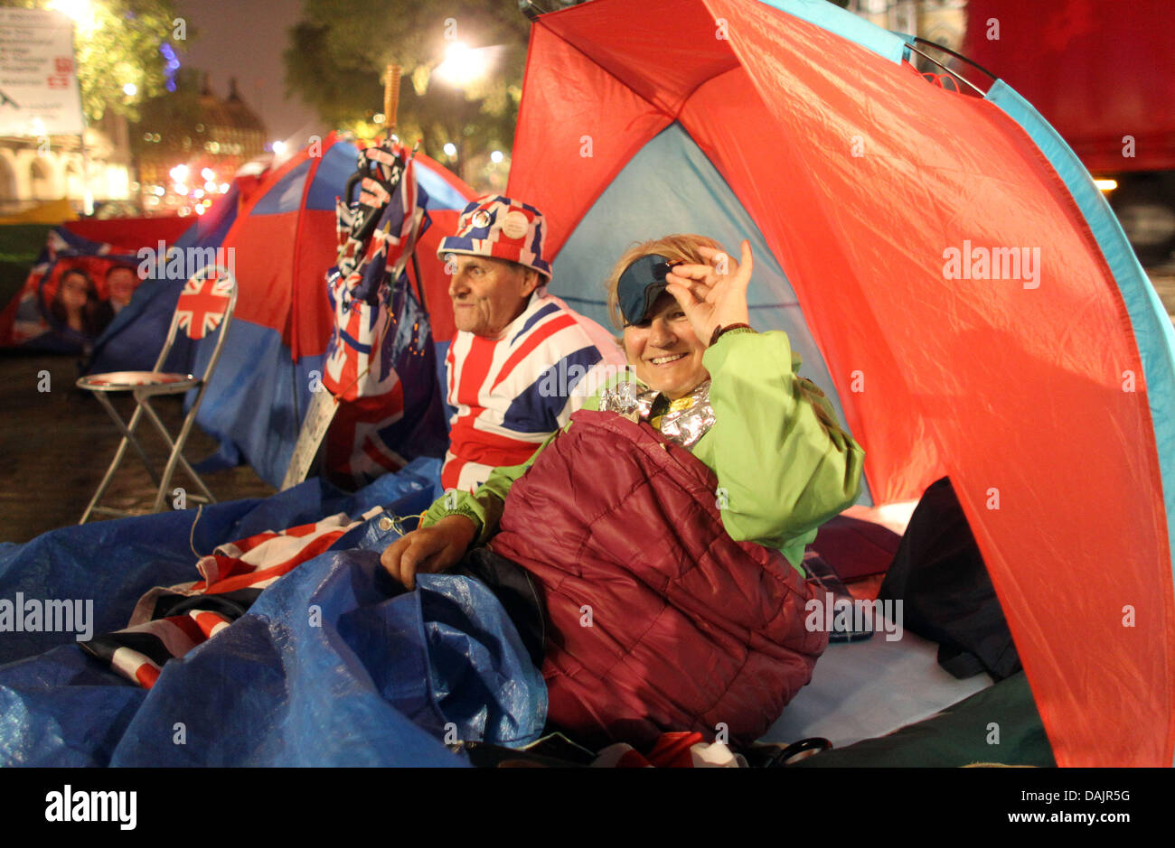 Terry Hutt and Jennifer Hawkins sit in their tent in front of Westminster Abbey at night waiting for the upcoming royal wedding in London, Britain, 27 April 2011. London is preparing for the royal wedding between Britain's Prince William and Kate Middleton at Westminster Abbey on April 29. Photo: Kay Nietfeld dpa Stock Photo