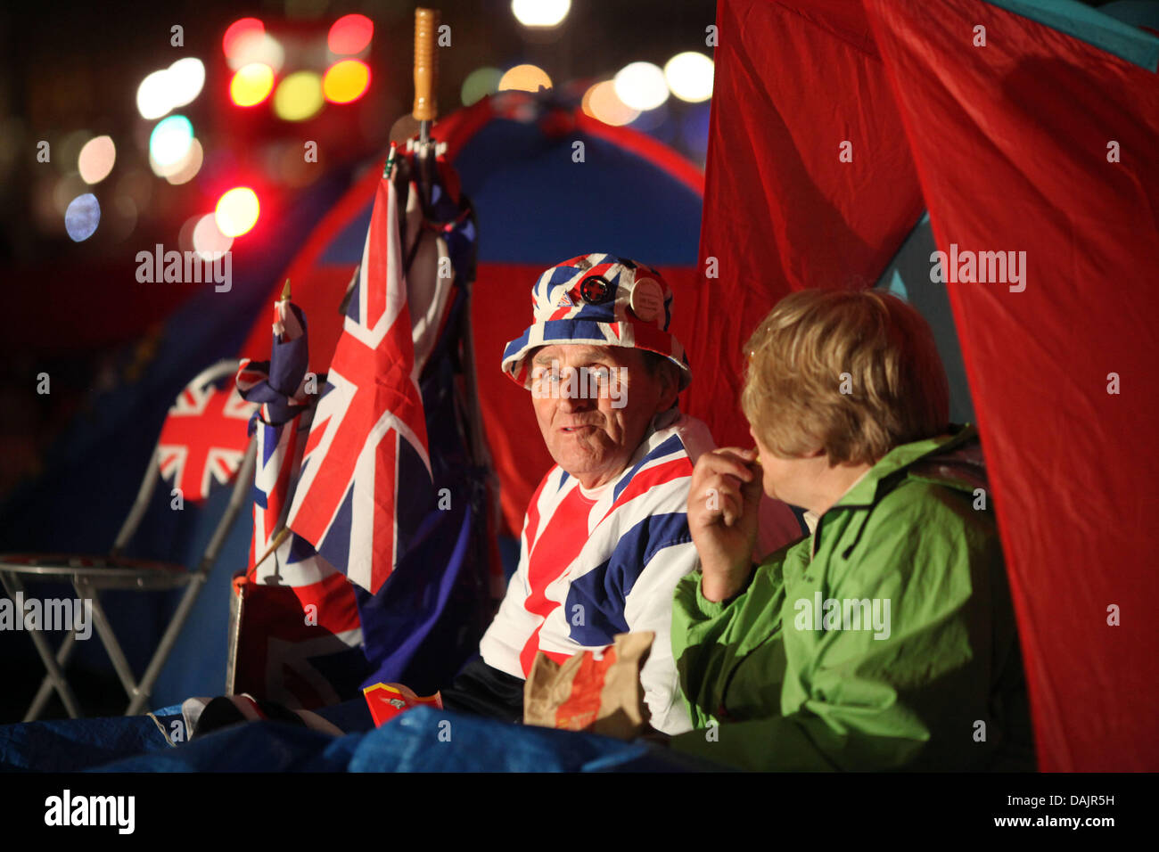 Terry Hutt and Jennifer Hawkins sit in their tent in front of Westminster Abbey at night waiting for the upcoming royal wedding in London, Britain, 27 April 2011. London is preparing for the royal wedding between Britain's Prince William and Kate Middleton at Westminster Abbey on April 29. Photo: Kay Nietfeld dpa Stock Photo