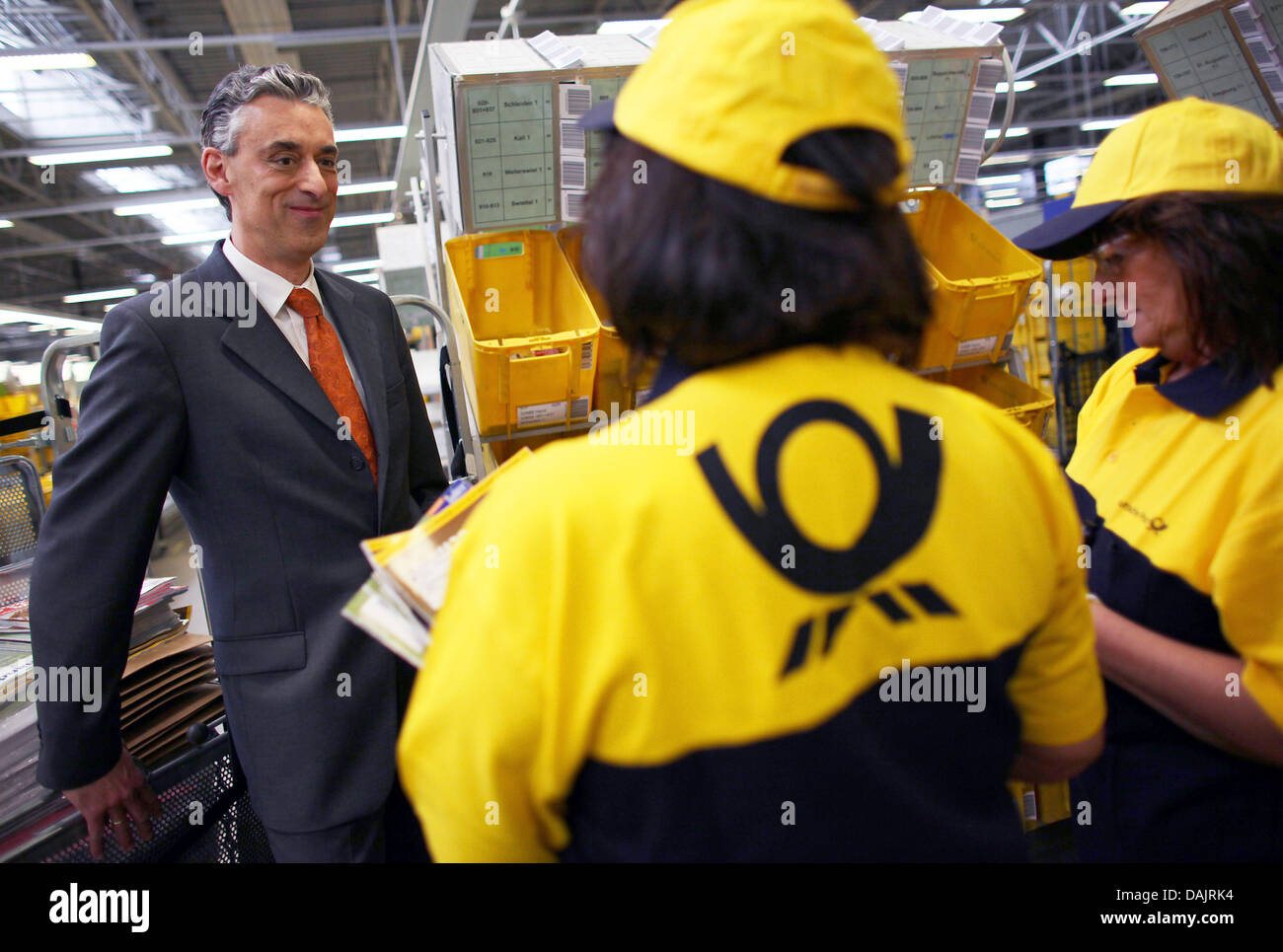 CEO of the Deutsche Post (German Mail) and the mail service DHL, Frank Appel (L), speaks to employees at a mail distribution centre in Troisdorf, Germany, 27 April 2011. Photo: Oliver Berg Stock Photo