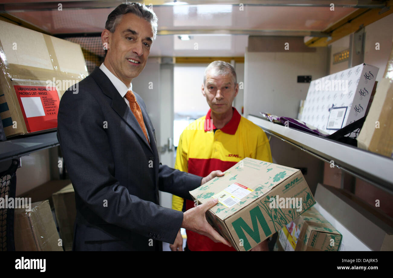 CEO of the Deutsche Post (German Mail) and the mail service DHL, Frank Appel (L), speaks to employees at a mail distribution centre in Troisdorf, Germany, 27 April 2011. Photo: Oliver Berg Stock Photo