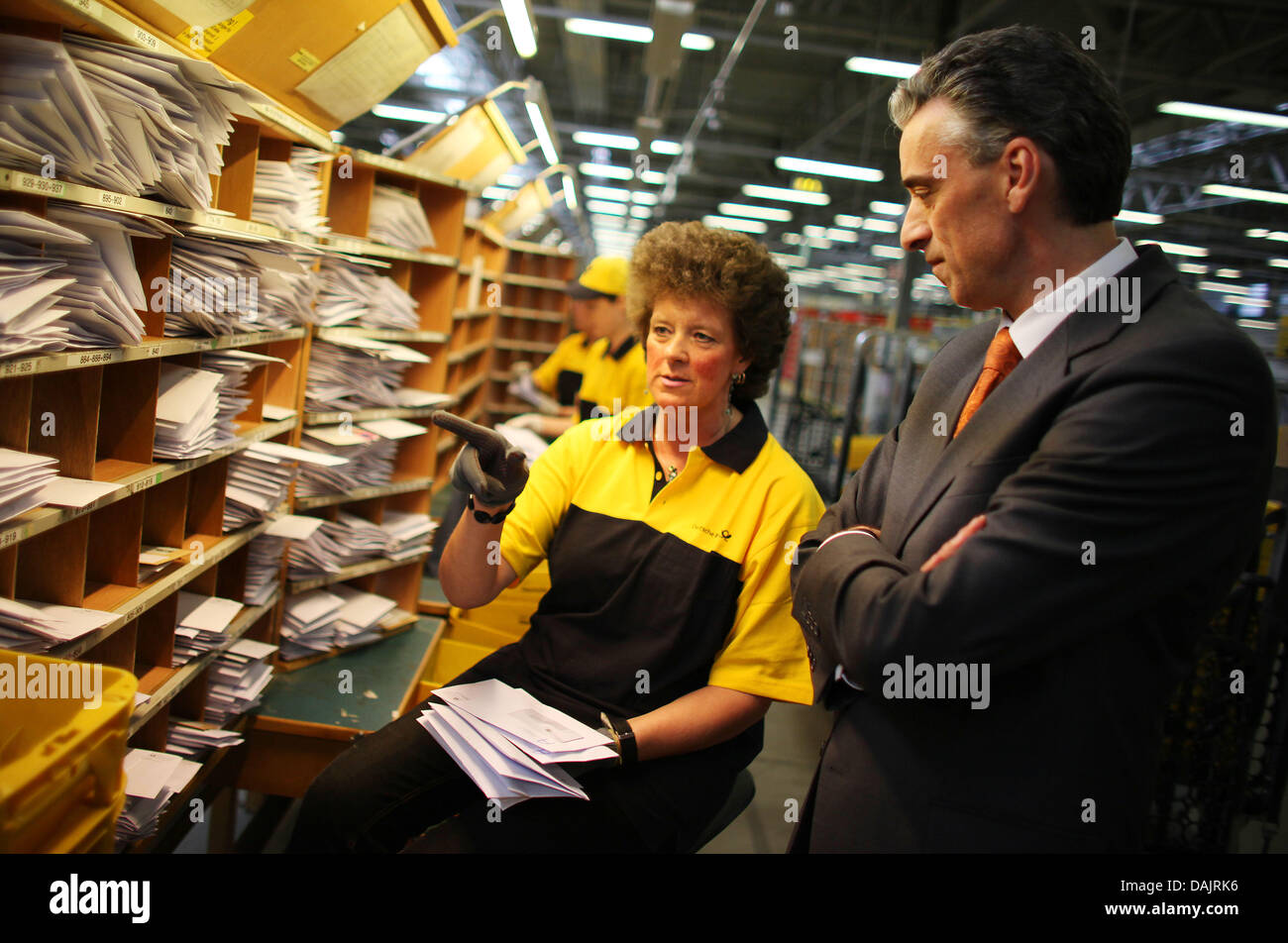 CEO of the Deutsche Post (German Mail) and the mail service DHL, Frank Appel (R), speaks to employees at a mail distribution centre in Troisdorf, Germany, 27 April 2011. Photo: Oliver Berg Stock Photo