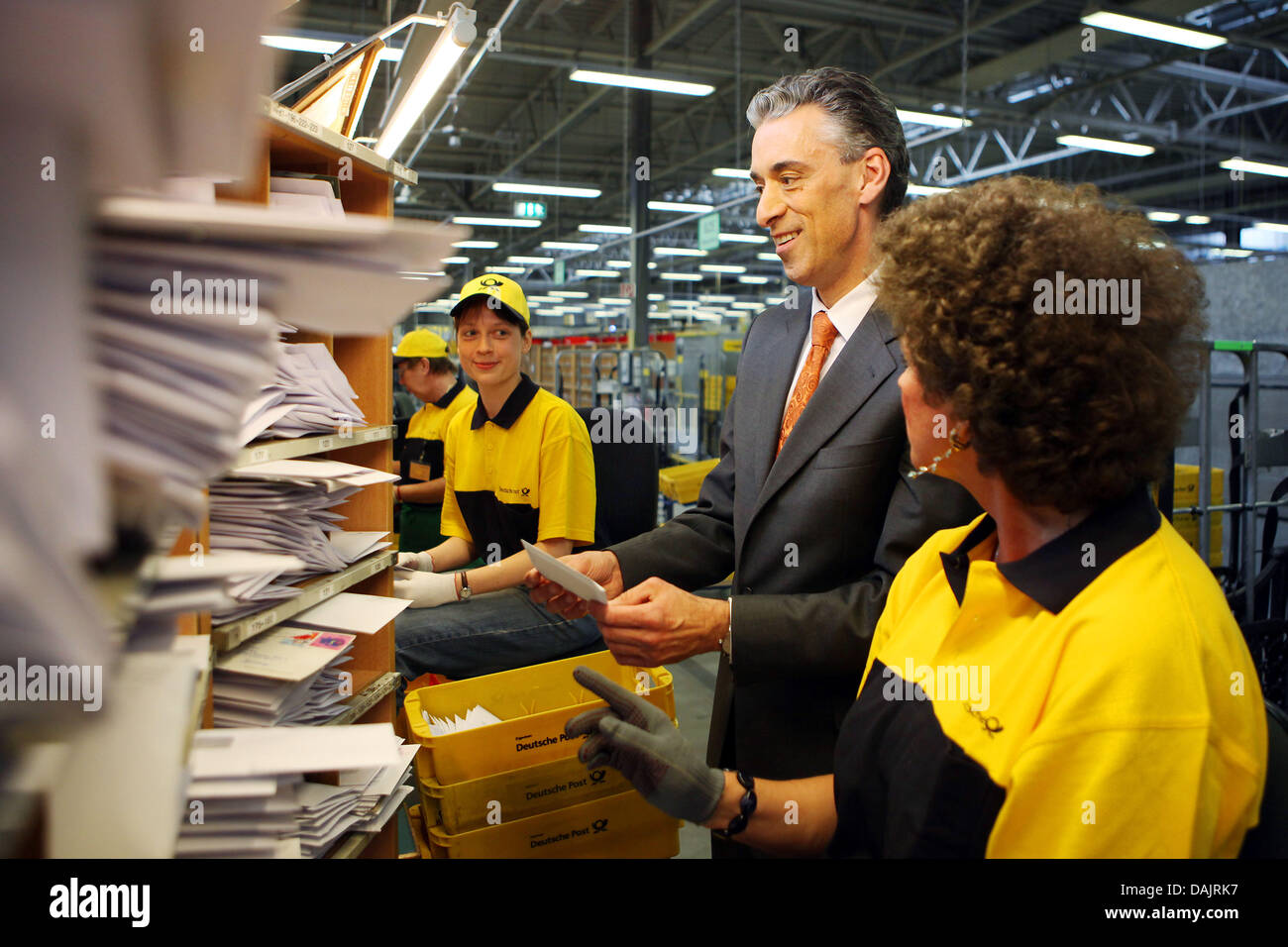 CEO of the Deutsche Post (German Mail) and the mail service DHL, Frank Appel (C), speaks to employees at a mail distribution centre in Troisdorf, Germany, 27 April 2011. Photo: Oliver Berg Stock Photo