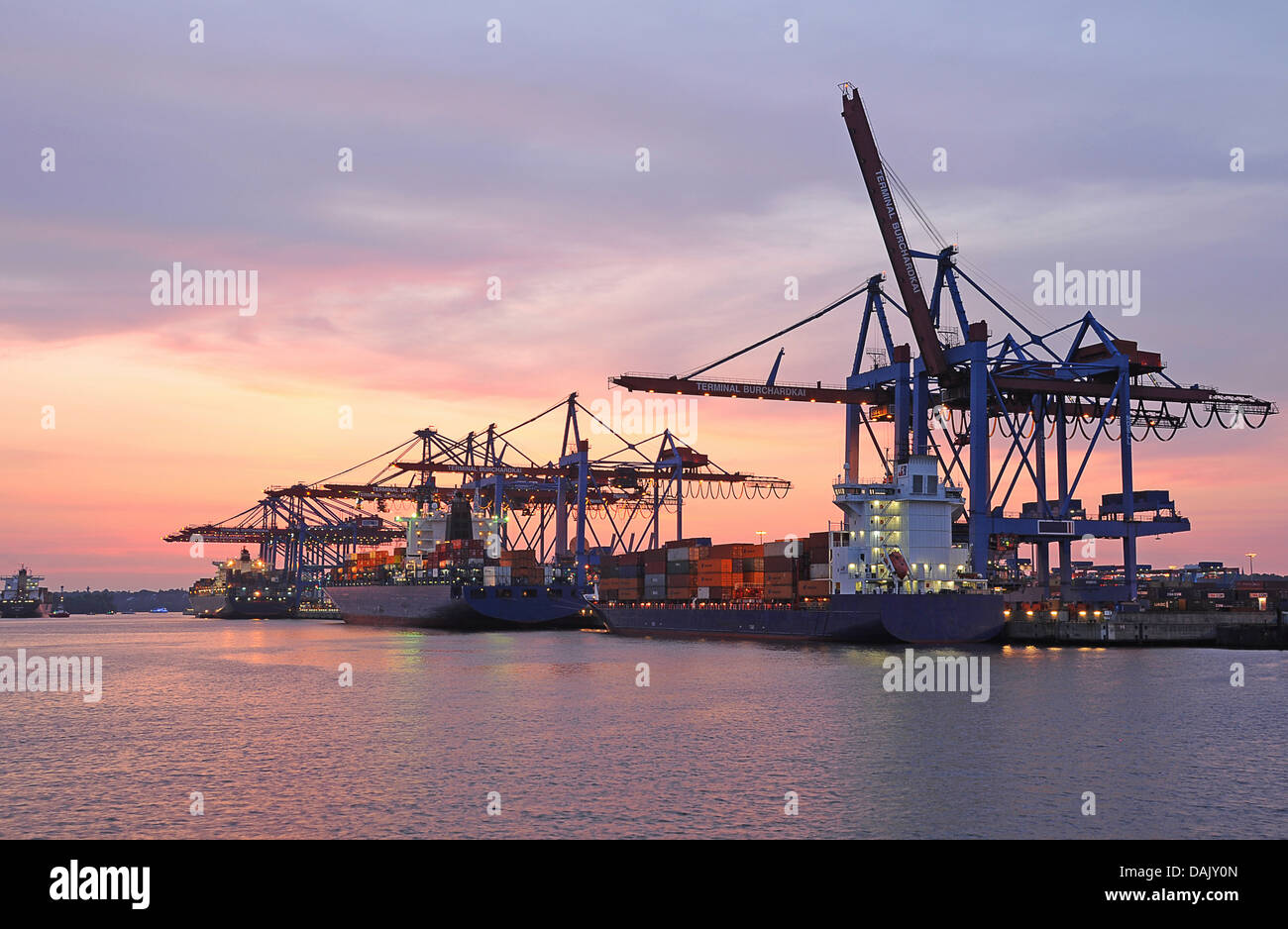 Container ships in the port at dusk Stock Photo - Alamy