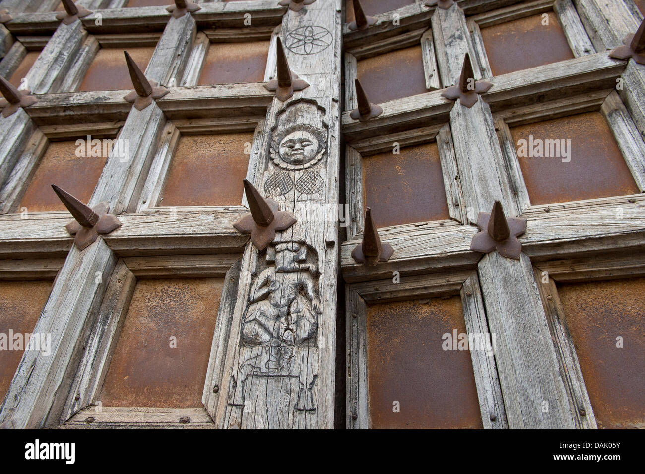 Palace gate fortified with iron spikes, representation of the elephant-headed god Ganesha and the sun, Taragarh Fort Stock Photo