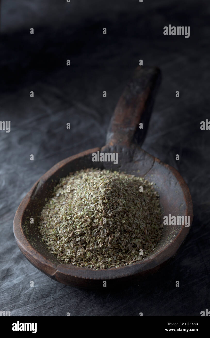 Grained oregano in wooden spoon, close up Stock Photo