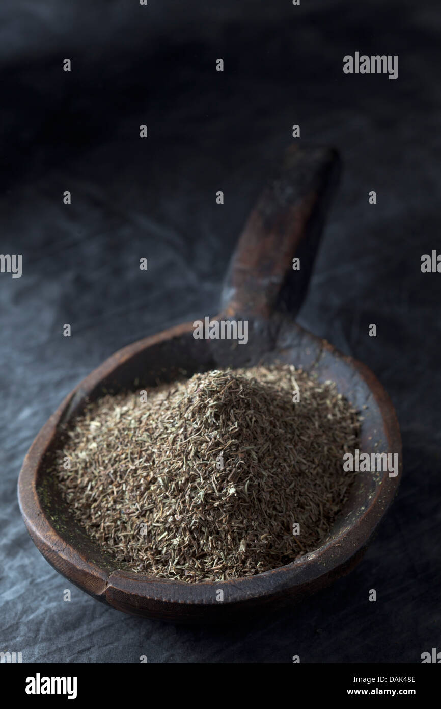 Grained thyme in wooden spoon, close up Stock Photo