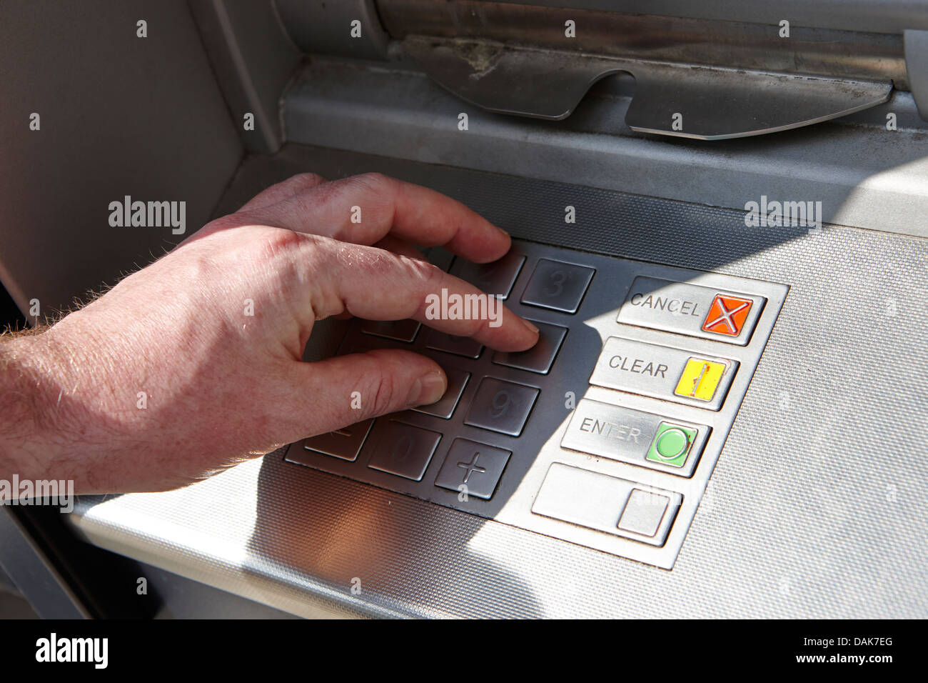 man operating atm cash machine entering pin london, england uk Stock Photo