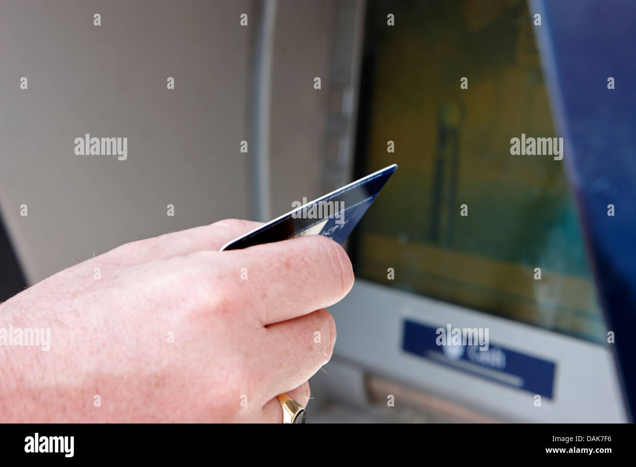 man operating atm cash machine debit card in hand london, england uk Stock Photo