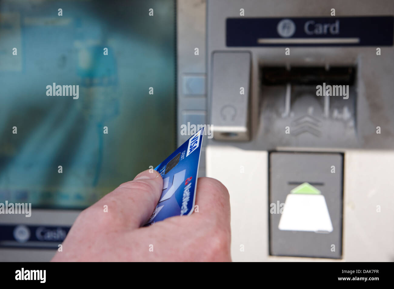 man operating atm cash machine debit card in hand london, england uk Stock Photo