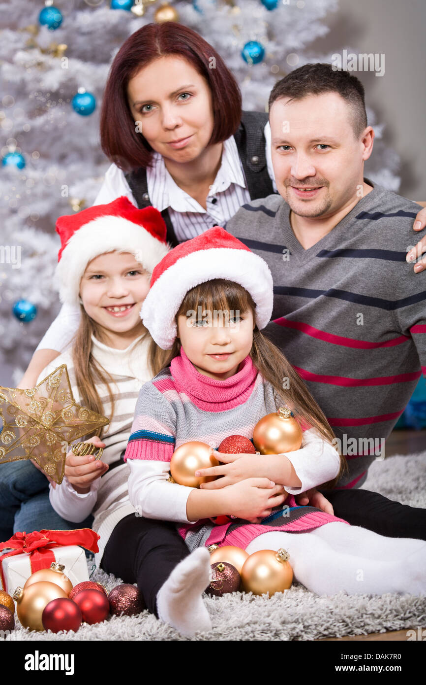 young family in front of christmas tree Stock Photo Alamy