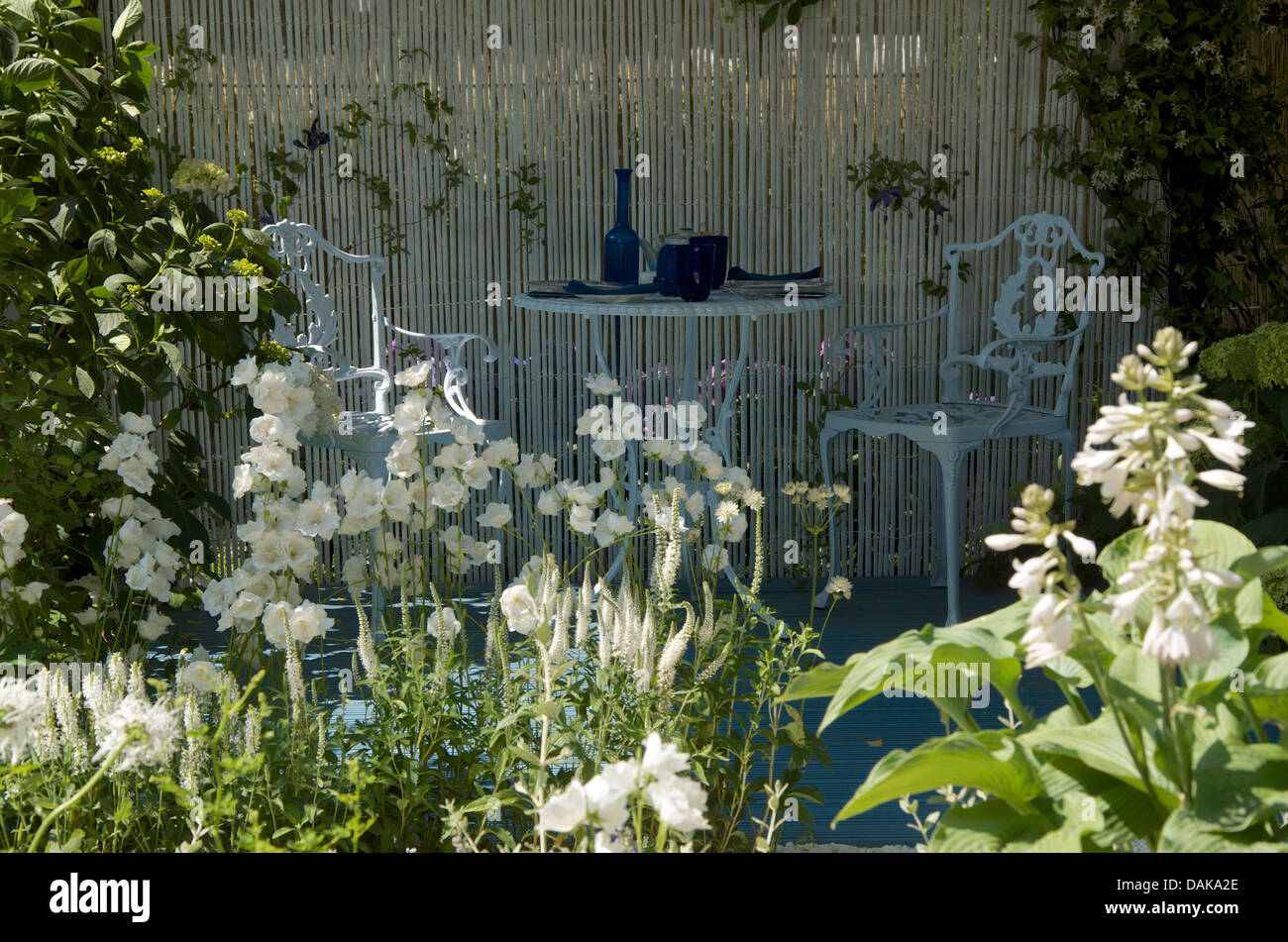 Table and two chairs in The Willow Pattern Summer Garden at RHS Hampton Court Palace Flower Show 2013. Stock Photo