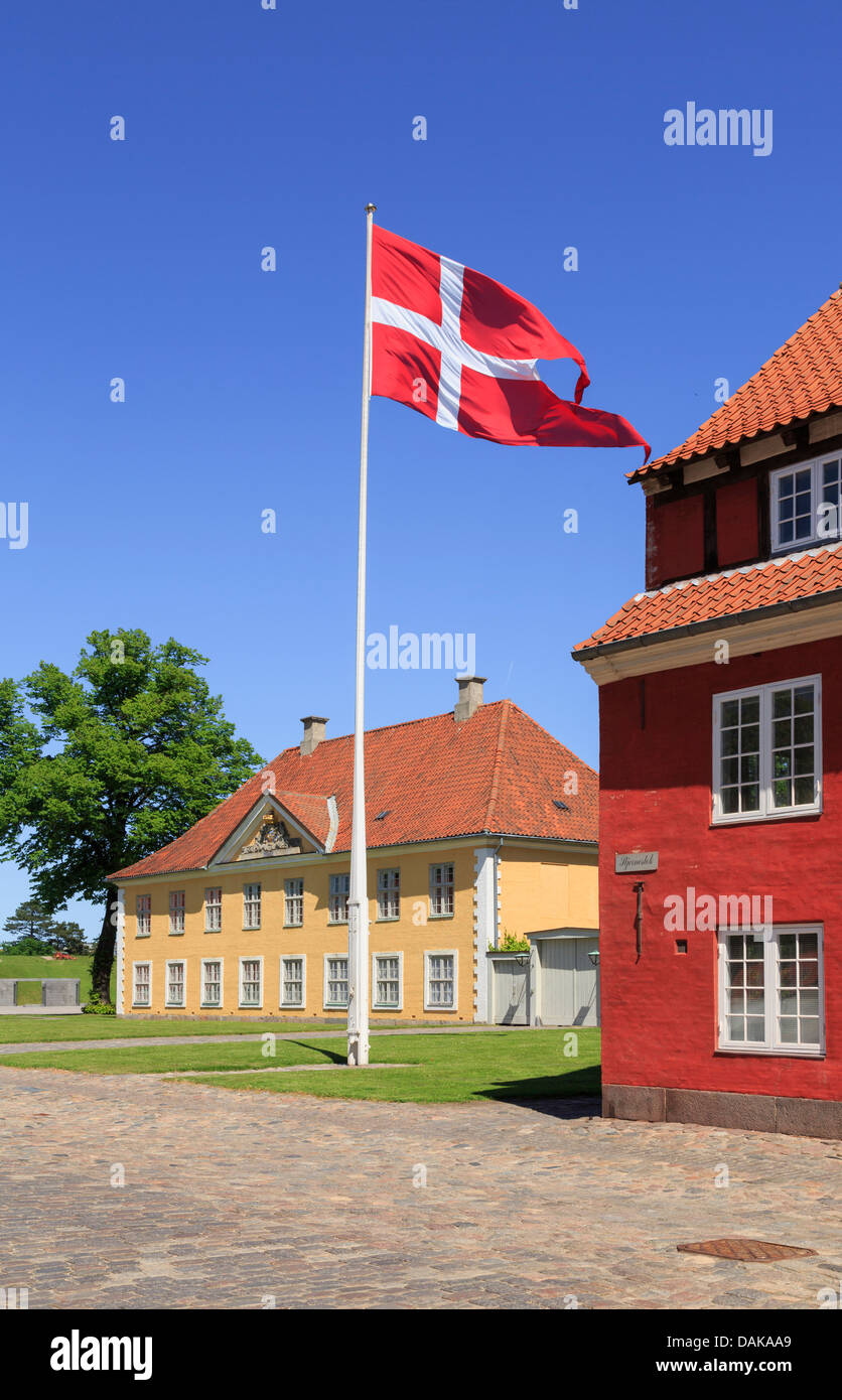 Danish flag by barracks and Commander's House in fortified Kastellet or Frederikshavn Citadel in Copenhagen, Zealand, Denmark Stock Photo