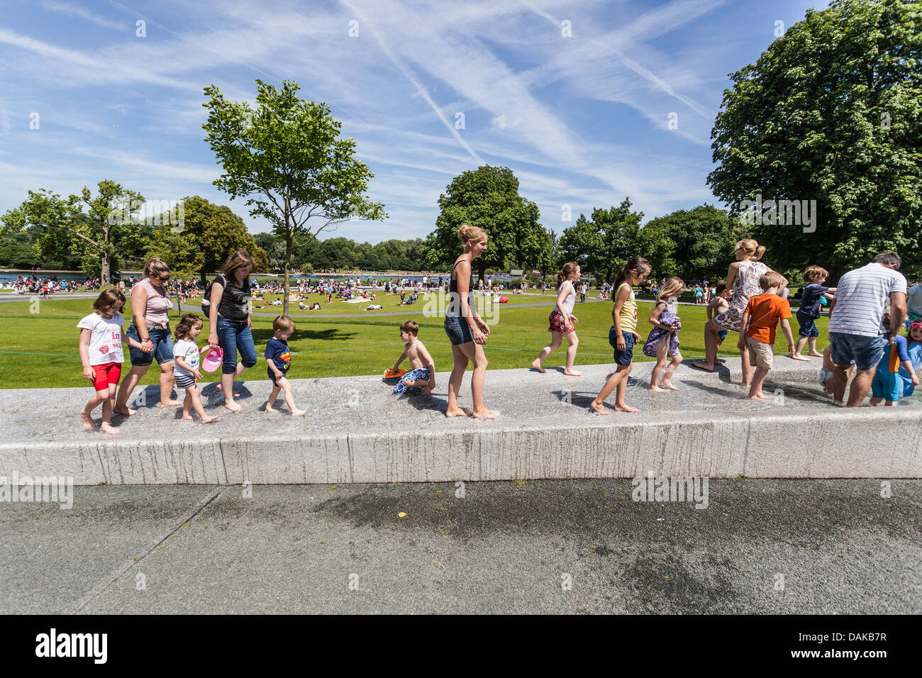 Families enjoying a sunny summer time at Princess Diana Memorial Fountain, Hyde Park, London, England, UK Stock Photo