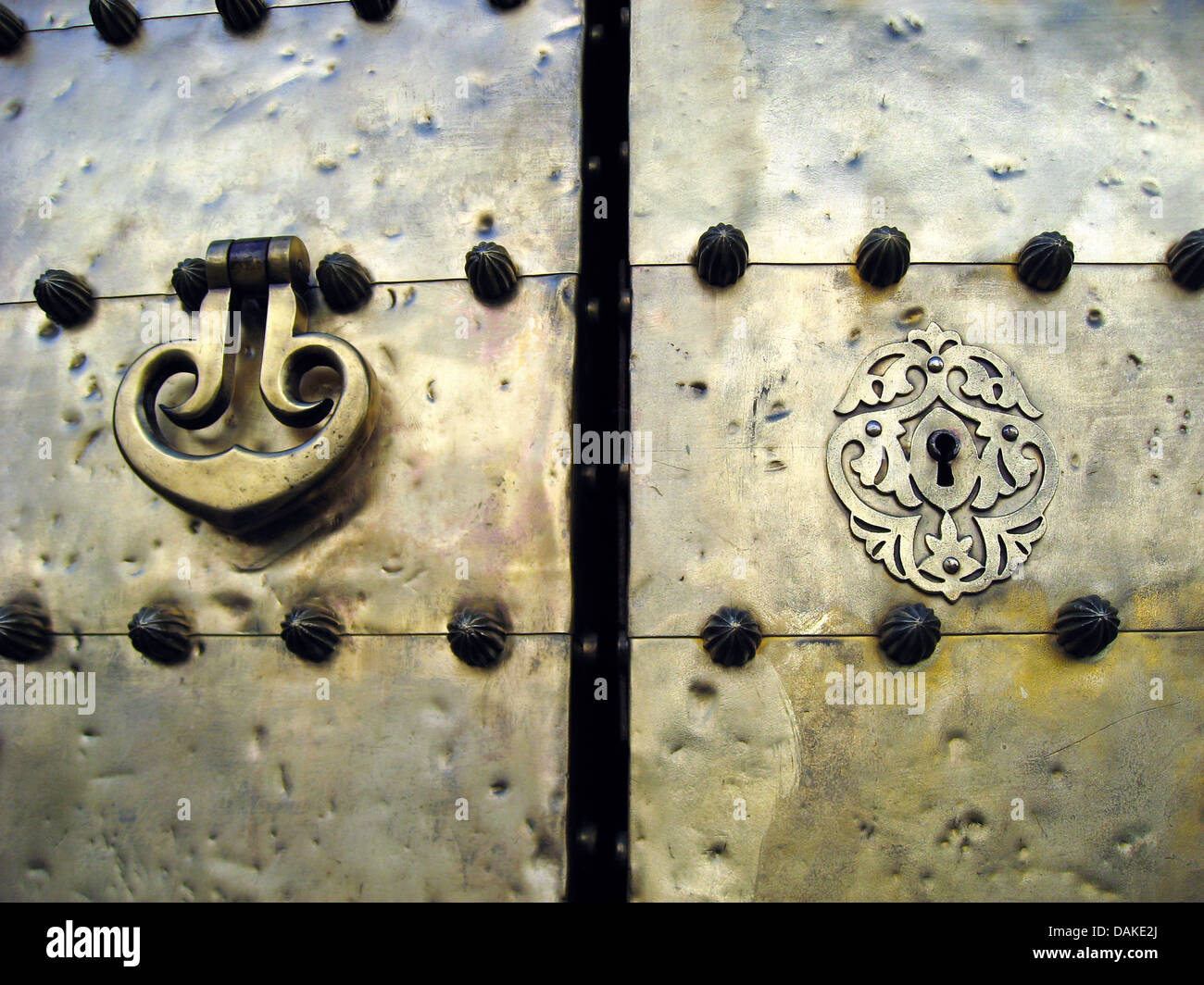 Golden metallic door, door handler / knocker and locker with arabesque designs. Stock Photo